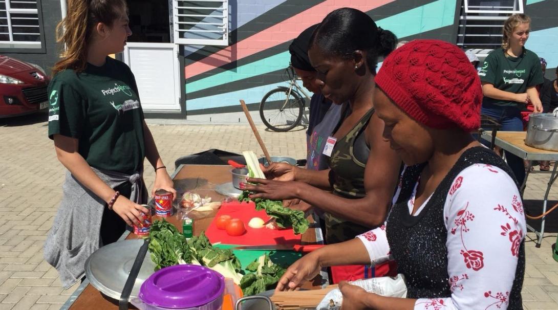 A group of South African women are pictured cooking healthy meals during a cooking competition, taken by a Projects Abroad intern whilst on her nutritional internship in South Africa. An intern on a nutritional internship in South Africa pictures a trio of women cooking healthy meals as part of a cooking competition.